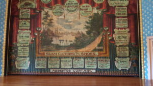Stoughton Opera House interior view of the stage with house curtain showing old-time business promotions from around Stoughton; the Goose Crown Inn