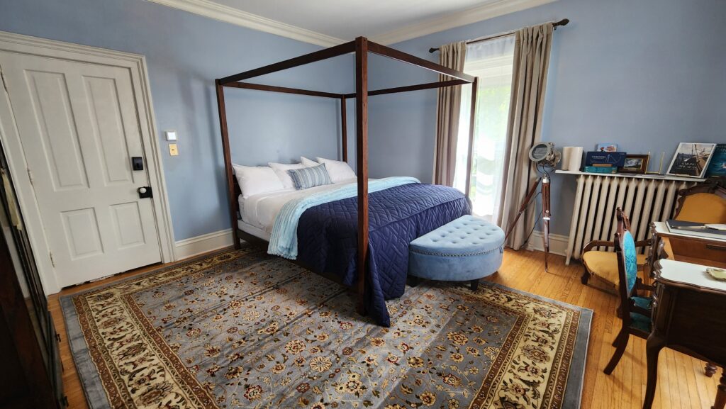 Canopy king bed in light-blue room with nautical themes; the Goose Crown Inn