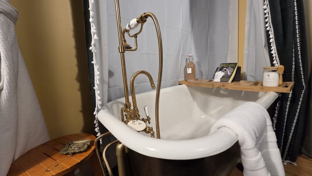 Clawfoot tub with reading tray, bath salts and bubble bath; the Goose Crown Inn of Stoughton