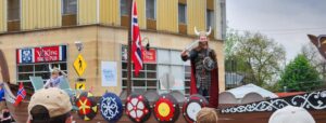 Syttende Mai festival celebrating Norwegian heritage in Stoughton Wisconsin. A viking waves his sword from a viking ship in the Syttende Mai parade; the Goose Crown Inn