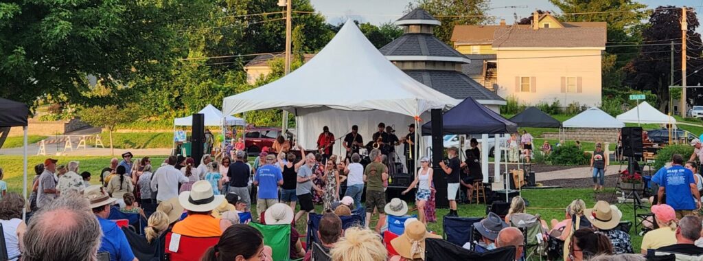 The Jimmys play to a crowd of people at the Catfish River Music Festival in Stoughton, Wisconsin; the Goose Crown Inn