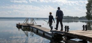 Fishing on a lake near Stoughton Wisconsin - a father and son head out on the dock of a peaceful lake; the Goose Crown Inn