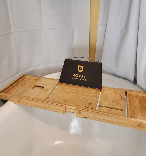 A bamboo bathtub tray with compartments and a book or tablet holder, labeled "Royal Craft Wood," placed across a white bathtub. , The Goose Crown Inn