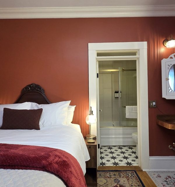 Inn guest room with queen bed, modern updated bathroom, and vinyl LPs decorating the walls; the Goose Crown Inn