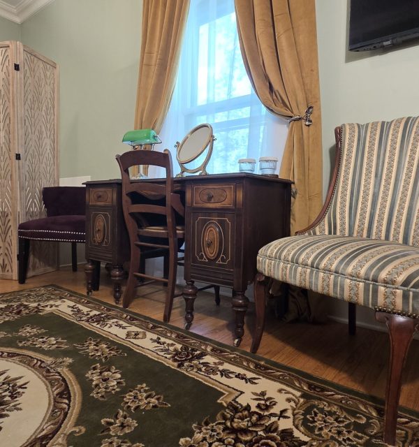 Living area in Sanctuary Suite of the Goose Crown inn; desk with vanity mirror and lamp.